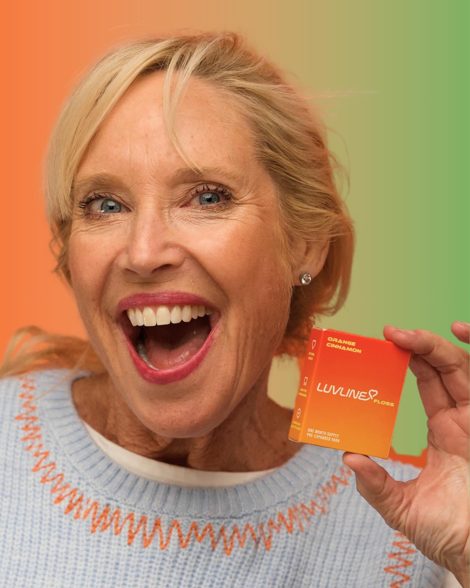 A LuvLine customer smiling and holding the Orange Cinnamon carton